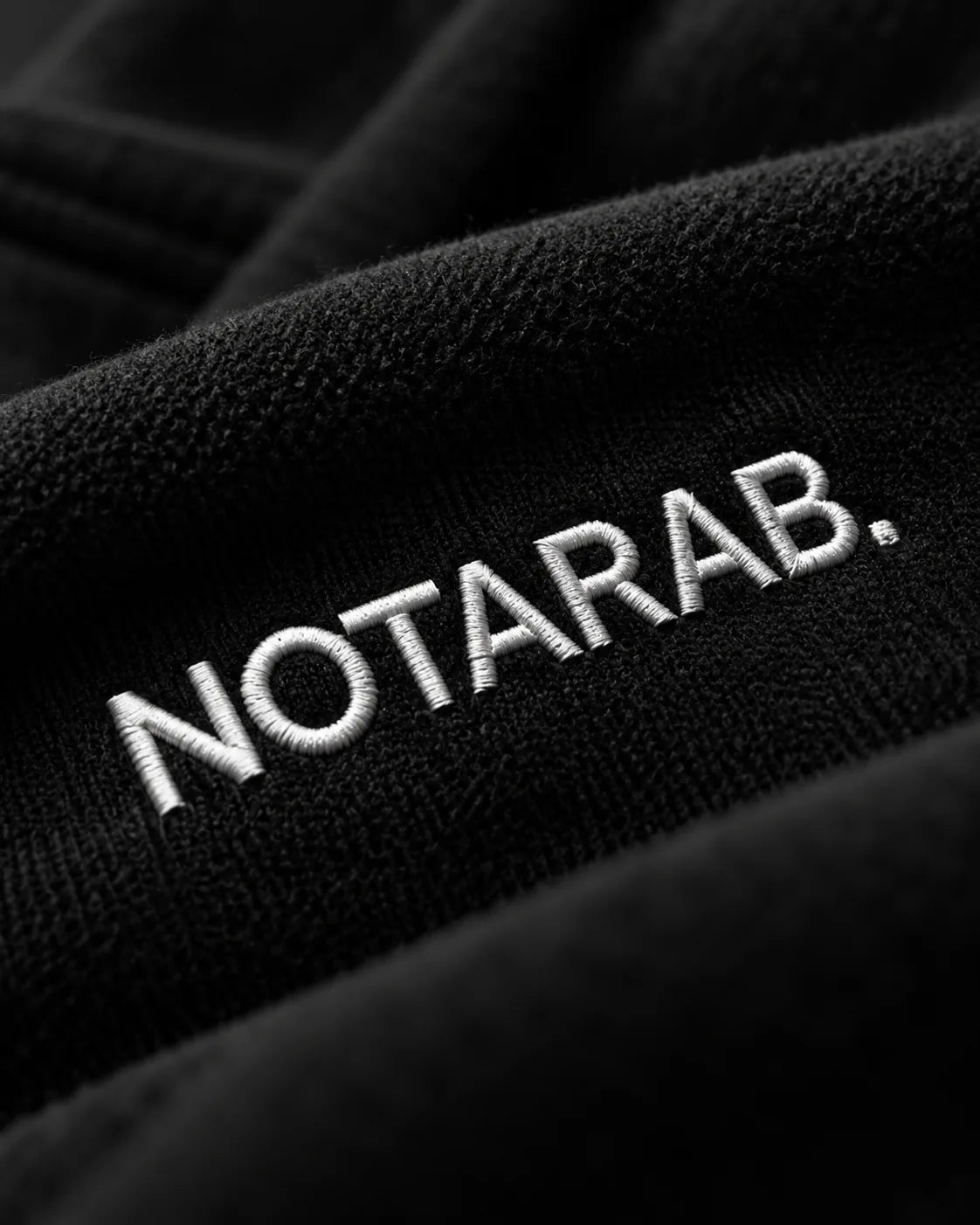 Close-up of the NOTARAB. embroidery on black fleece